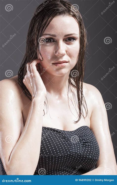 Portrait Of Caucasian Sensual Brunette Touching Neck And Showing Wet And Shining Skin And Wet