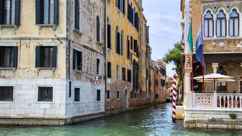 streets and canals of venice italy ancient houses flowers in the windows and the sea stock
