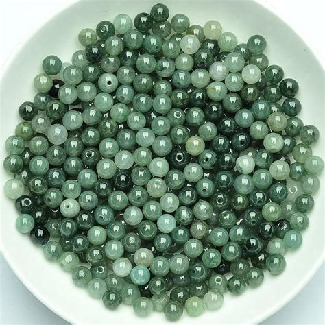 A White Bowl Filled With Lots Of Green Beads