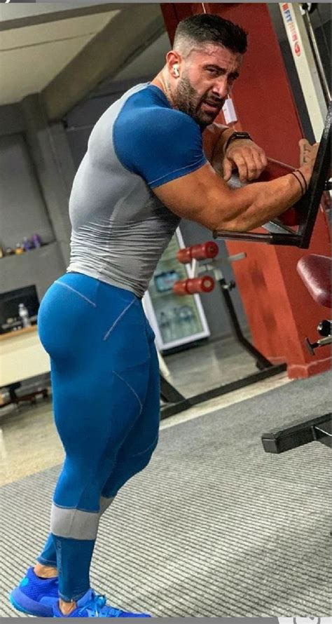 muscular men doing squats with barbell