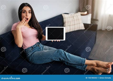 Distracted Young Woman Look On Camera She Sit On Sofa In Room Model Wonder She Hold Hand On