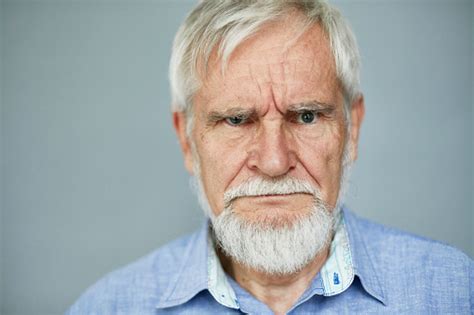 Portrait Of Stern Caucasian Man Scowling At Camera Stock Photo