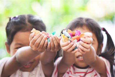 Two Asian Child Girls Holding Sweet Candies In Thier Hands Stock Image