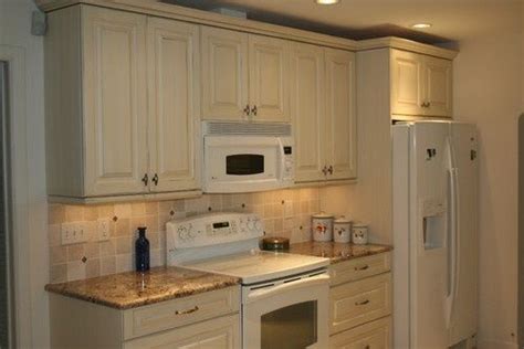 Cream colored kitchen cabinets with white appliances. What do you think looks better with white applicances ...