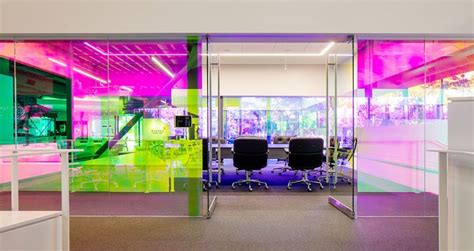 An Office With Colorful Glass Walls And Chairs