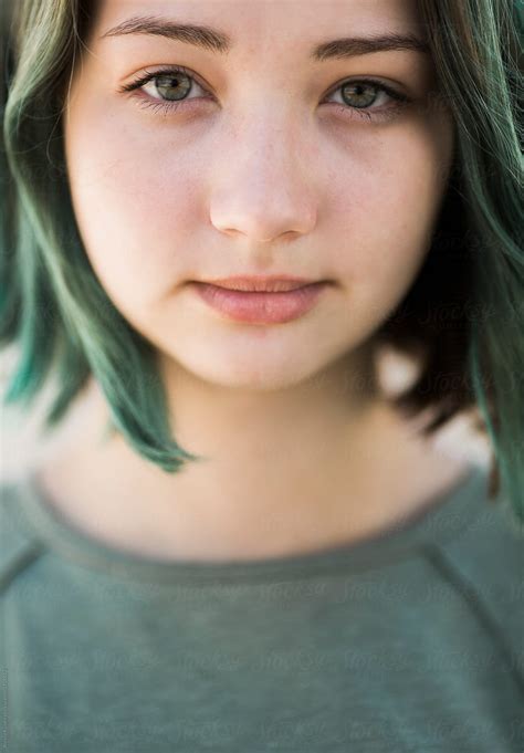 Pretty child with dark hair and beautiful face adorably smiles. close up of a cute teen girl with green hair by Alexey Kuzma - Green, Teen - Stocksy United
