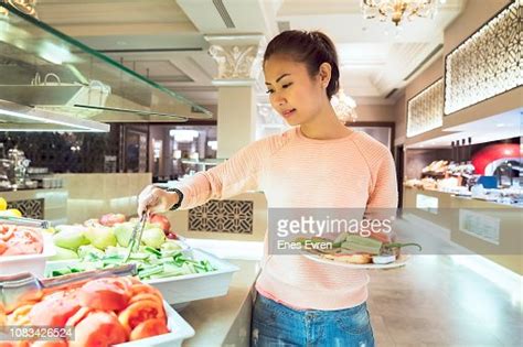 Woman Helping Herself To The Breakfast Buffet In A Luxury Hotels