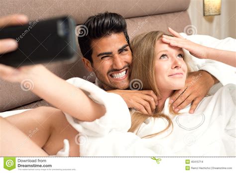 Couple In Bed Taking A Selfie And Having Fun Couple In