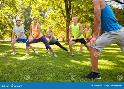 Gente Feliz Haciendo Ejercicio Con El Entrenador En El Parque Imagen De Archivo Imagen De