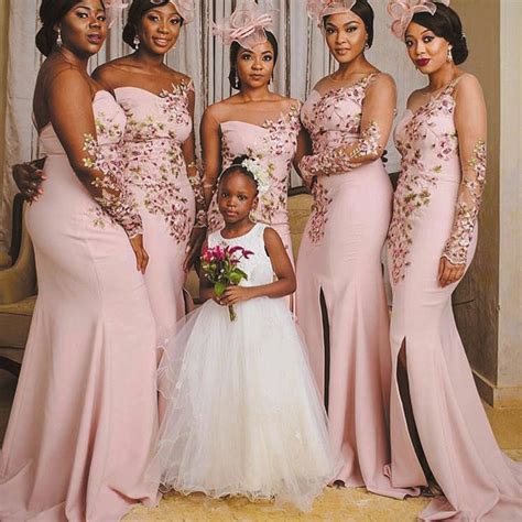 A Group Of Women Standing Next To Each Other Wearing Dresses And Holding Bouquets In Their Hands