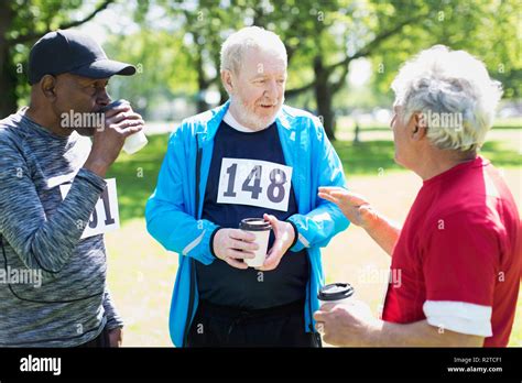 Active Senior Men Friends Finishing Sports Race And Drinking Coffee In