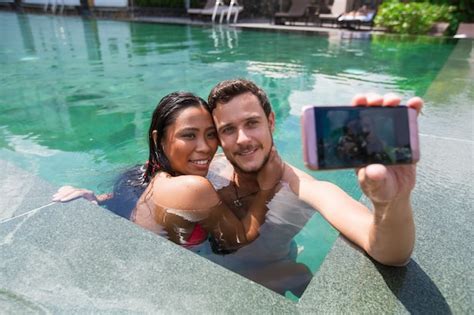 Premium Photo Happy Interracial Couple Taking Selfie In Pool