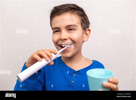 Six Years Old Boy With Electric Toothbrush On White Background Close