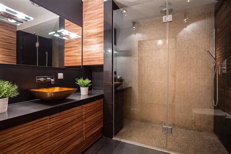 A Bathroom With A Glass Shower Door And Wooden Cabinetry On The Wall
