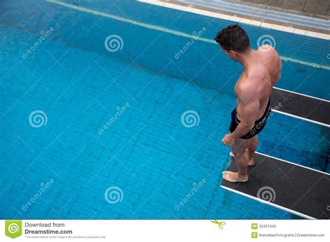 Man Standing On Diving Board At Public Swimming Pool Stock Image