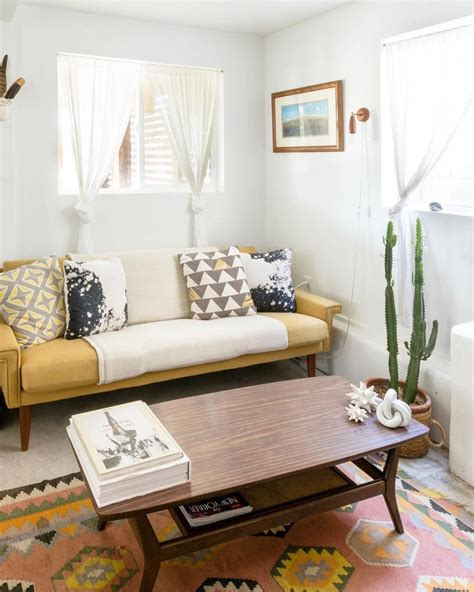 A Living Room With A Couch Coffee Table And Potted Cactus In The Corner