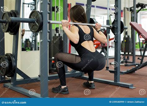 Fit Woman Doing Squats With A Barbell In Smith Machine Stock Image