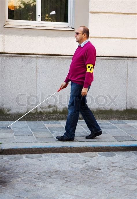 A Blind Man Walks With A Cane On A Street Stock Photo Colourbox