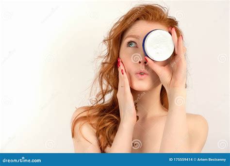 Redhead Girl With Clean Skin In A Towel Looking Up Closing One Eye