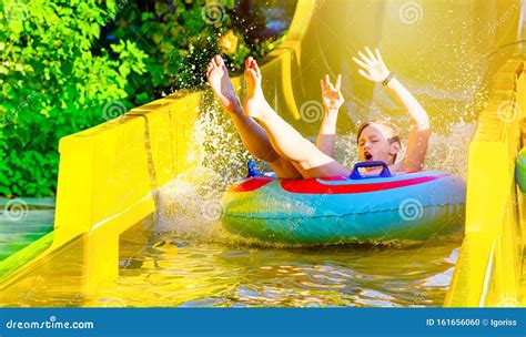 Boy Having Fun On Yellow Water Slide At Water Park Stock Photo Image