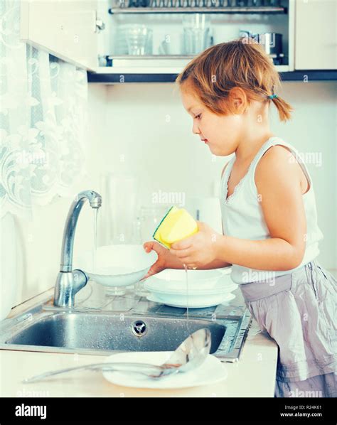 Serious Little Child Washing Dishes At Domestic Kitchen Stock Photo Alamy