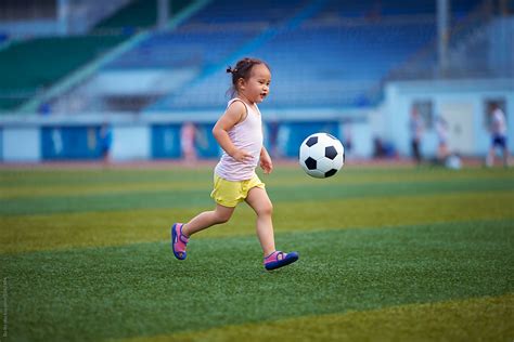 Little Girl Playing Football Outdoor In The Football Field Del