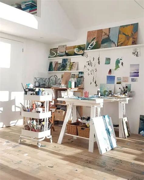 An Artists Studio With Lots Of Art Work On The Walls And Wooden Floors