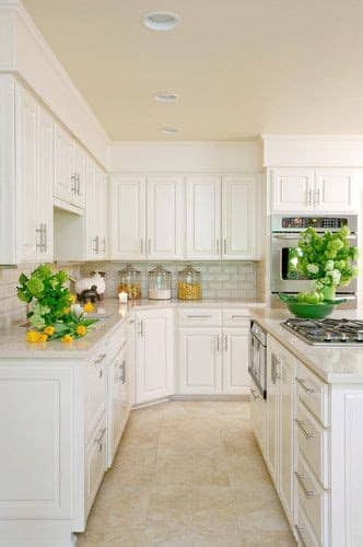 Painting cabinets high gloss white, installing a shiny beige marble type tile for flooring, looking at a dark gray countertop. Kitchen with white cabinets and travertine tile floor ...