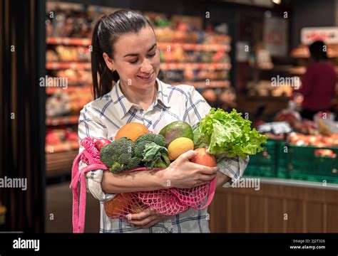 Young Woman In A Supermarket With Vegetables And Fruits Buying