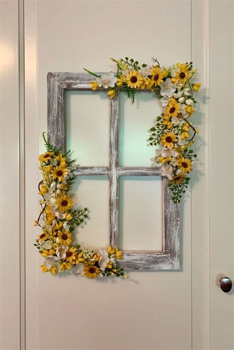 An Old Window Frame Is Decorated With Flowers And Greenery To Decorate