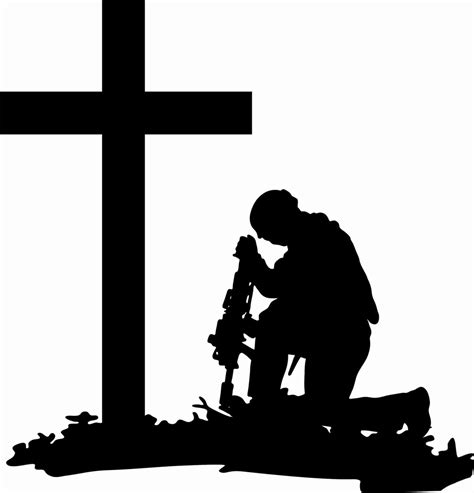 A Man Kneeling In Front Of A Cross With A Small Machine On Its Side