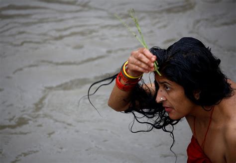 a woman performs a ritual as she take a holy bath in the bagmati river during the rishi