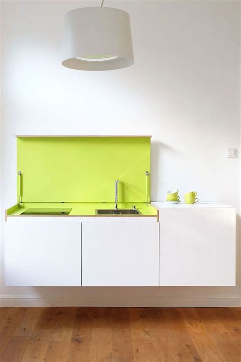 A Kitchen With White Cabinets And Lime Green Counter Tops In The Center