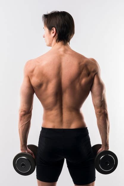 Free Photo Back View Of Shirtless Athletic Man Holding Weights