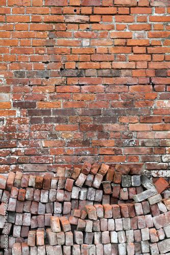 Old Distressed Red Brick Wall Background With A Pile Of Bricks In The
