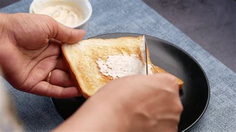 Women Hand Spreading Low Fact Cheese Cream Spread On A Bread Stock