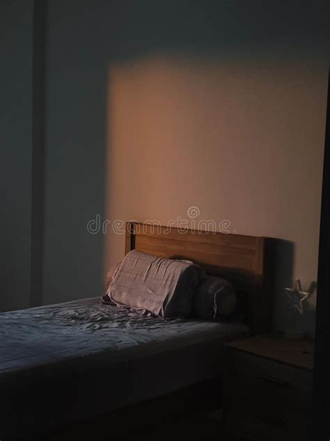 Sun Shining Into A Bedroom Lighting Up The Pillow And Wall Stock Photo