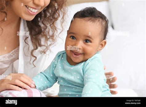 Happy African American Mother With Cute Little Baby In Bedroom Stock