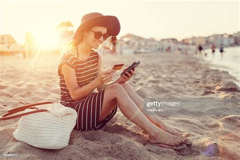Woman Using Credit Card At The Beach Photo Getty Images