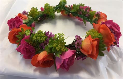 A Flower Circlet In Hot Coloured Roses And Waxflower For