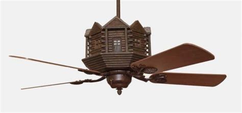 A Ceiling Fan With A Wooden House On Its Blades And Two Large Brown Blades