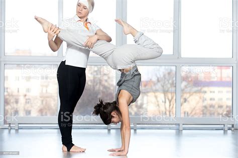 Teacher Helping Student To Do Stag Handstand Stock Photo Download