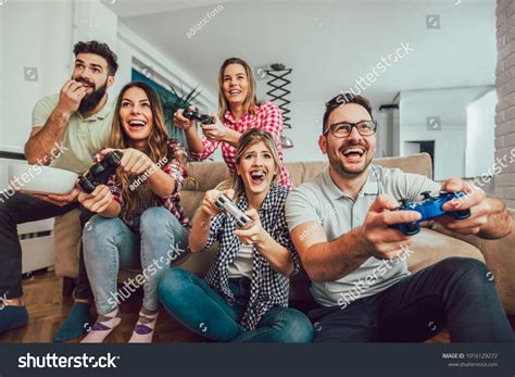 Group Of Friends Play Video Games Together At Home Having Fun Friend