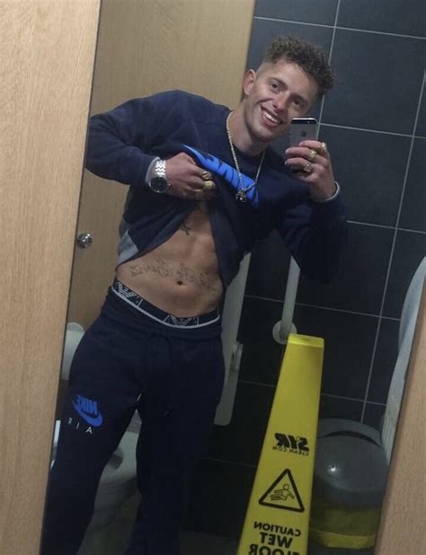A Man Is Taking A Selfie In The Bathroom With His Cell Phone And Tape Around His Waist