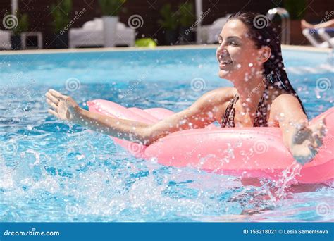 Outdoor Picture Of Relaxed Playful Female Having Fun In Swimming Pool Alone Lying On Pink Water