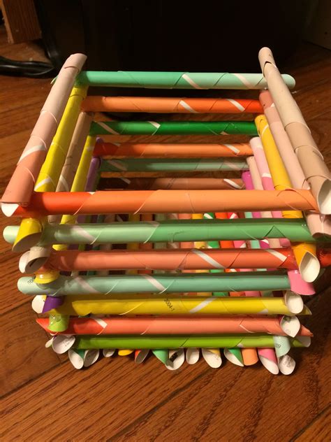 a stack of colored pencils sitting on top of a wooden table
