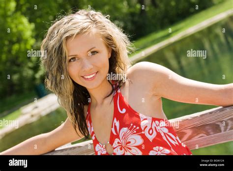 Caucasian Teenage Girl Standing On Bridge In A Park And Smiling Stock