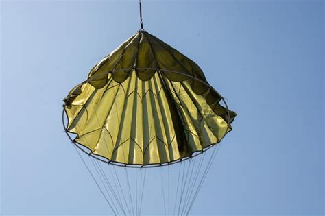 Premium Photo Parachuter Descending With Parachute Against Blue Sky