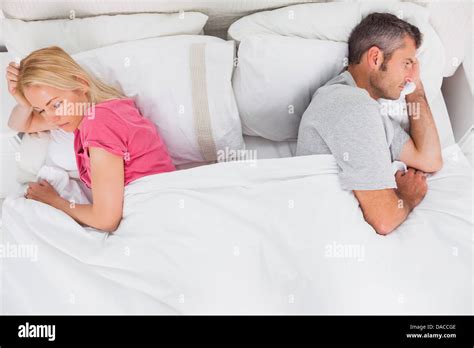 Upset Couple Lying Back To Back Stock Photo Alamy