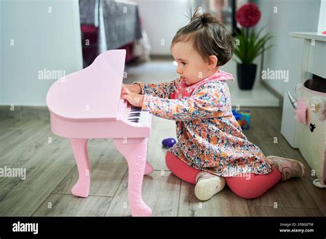 Baby Playing Piano While Sitting On Floor At Home Stock Photo Alamy